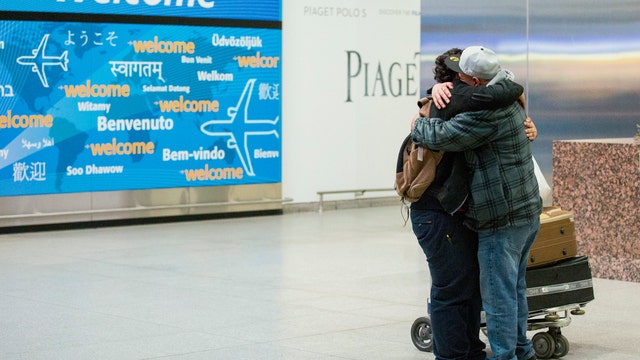 Travelers arrive in US to hugs and tears after ban is lifted