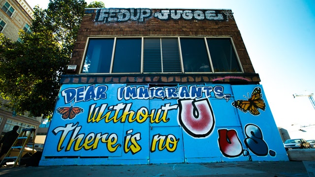Art guerrillas strike again: Indecline paints 'Dear immigrants' mural in Oakland