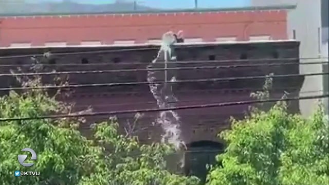 Video captures man dumping water on homeless woman down below on sidewalk
