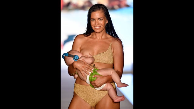 Swimsuit model rocks runway while nursing baby girl