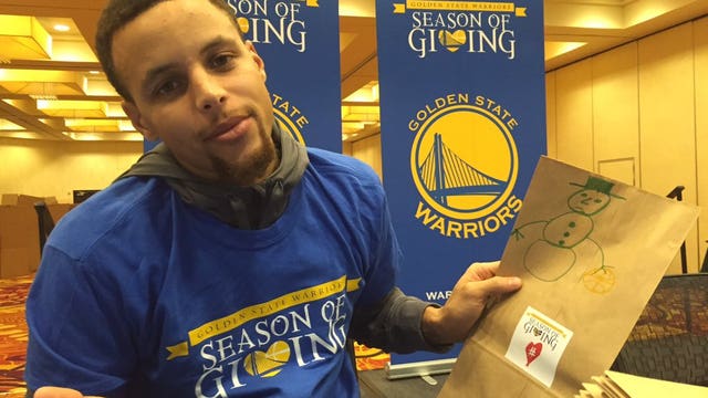 Golden State Warriors help stuff 20,000 lunch bags for the needy