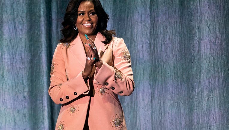 Former US first lady Michelle Obama gestures on stage of the Royal Arena in Copenhagen on April 9, 2019 during a tour to promote her memoir