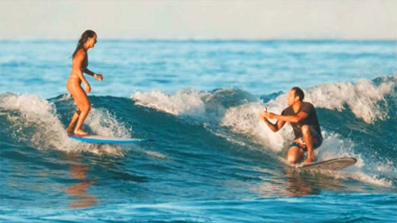Hawaii man proposes to girlfriend while surfing