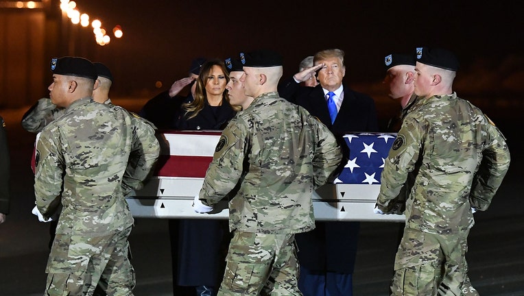 First lady Melania Trump and President Donald Trump watch as the remains of Chief Warrant Officer 2 David C. Knadle are carried during a dignified transfer at Dover Air Force Base in Dover, Delaware on November 21, 2019. (Photo by MANDEL NGAN/AFP via Getty Images)