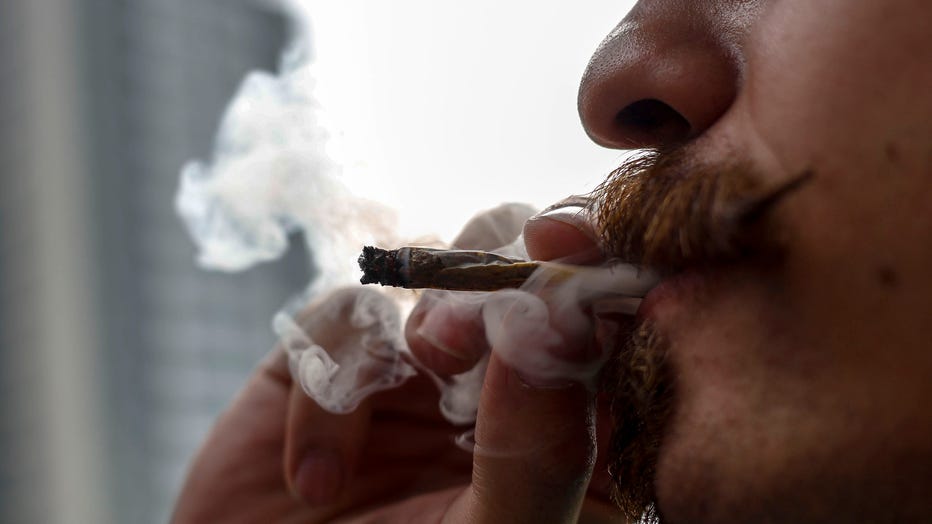 A file image shows a man smoking a joint during a march demanding the legalization of marijuana in Sao Paulo, Brazil, on June 1, 2019. (Photo credit: MIGUEL SCHINCARIOL/AFP via Getty Images)