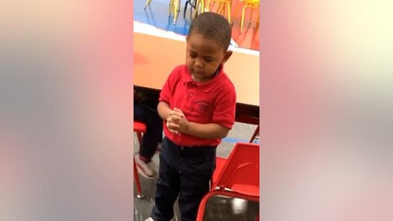 Toddler leads preschool lunch prayer before enjoying a meal with classmates
