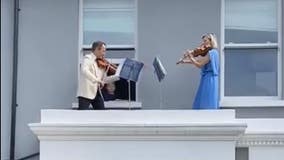Doctor and husband perform balcony violin concert for neighbors shut in amid COVID-19 lockdowns