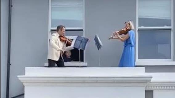 Doctor and husband perform balcony violin concert for neighbors shut in amid COVID-19 lockdowns