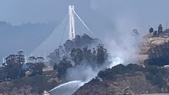 San Francisco firefighters knock down brush fire on Yerba Buena Island with fire boat
