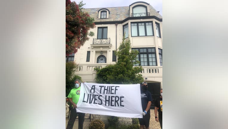 Protestors hold a sign that says