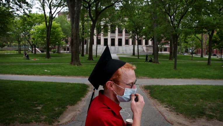 FILE - Harvard Law School graduate spends time on campus before attending the online graduation ceremony in his room.