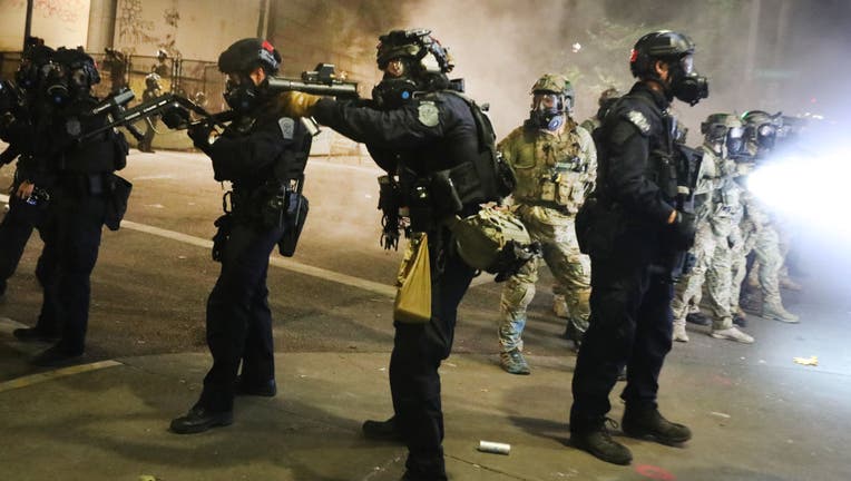 FILE - Federal police face off with protesters in front of the Mark O. Hatfield federal courthouse in downtown Portland as the city experiences another night of unrest. 