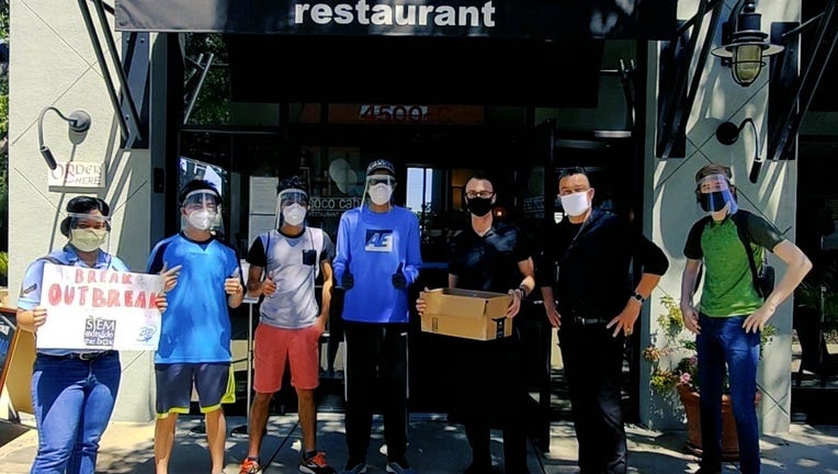 Members of Break the Outbreak Dublin chapter — which was founded by Dublin High School senior Sky Yang (second from left) — drop off vital PPE at Coco Cabana restaurant.
