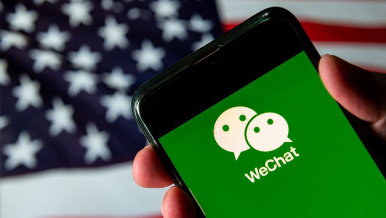 FILE - In this photo illustration the Chinese multi-purpose messaging social media and mobile payment app developed by Tencent, WeChat logo is seen on an Android mobile device with United States of America flag in the background.