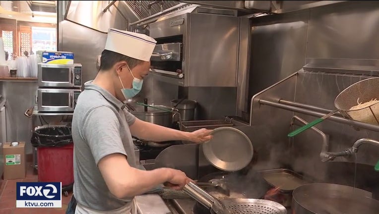 A chef wears a mask while cooking
