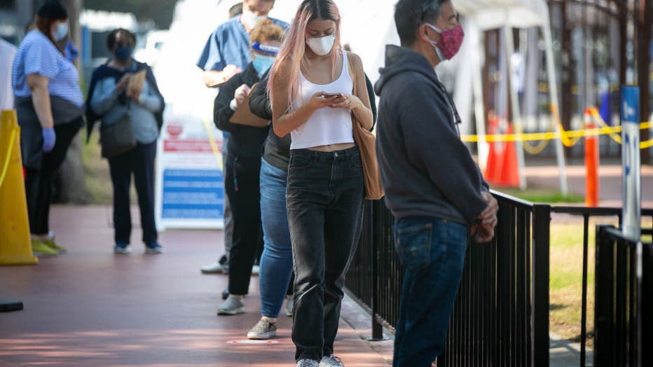 FILE - People line up for their turn at receiving the COVID-19 vaccine at Kedren Health on Feb. 11, 2021 in Los Angeles, California. (Jason Armond / Los Angeles Times via Getty Images)