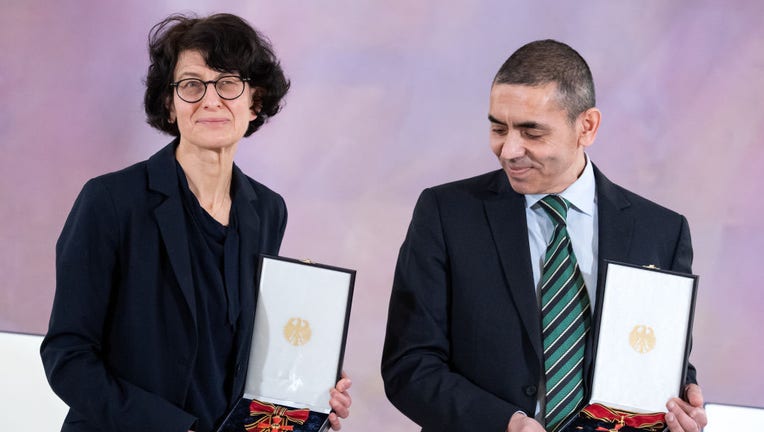 Özlem Türeci (L) and Ugur Sahin (r), founders of the coronavaccine developer BioNTech, stand during the award of the Grand Cross of Merit with Star of the Order of Merit of the Federal Republic of Germany on March 19, 2021 in Berlin, Germany. (Photo by Bernd von Jutrczenka/picture alliance via Getty Images)