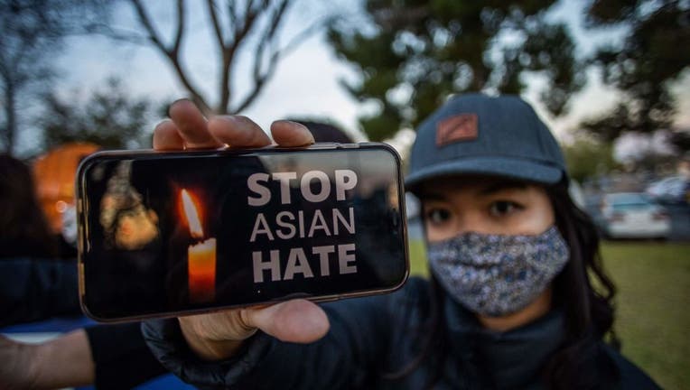 A woman holds her phone during a candlelight vigil in Garden Grove, California, on March 17, 2021 to unite against the recent spate of violence targeting Asians and to express grief and outrage over a shooting that left eight people dead in Atlanta, Georgia, including at least six Asian women. (Photo by APU GOMES/AFP via Getty Images)