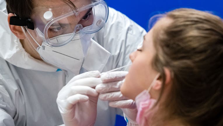 FILE - A worker administers a rapid antigen COVID-19 test to a high school student at the Ehrenfried Walther von Tschirnhaus Gymnasium high school on March 16, 2021 in Dresden, Germany. (Photo by Jens Schlueter/Getty Images)