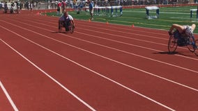 Coaches from both teams jump to help after wheelchair racer's tire breaks mid-race