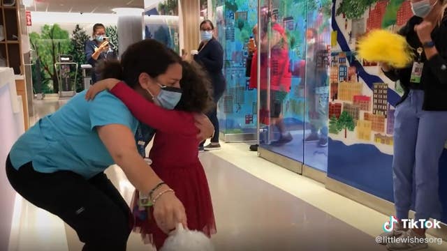Tearful celebration: 5-year-old cancer patient can't let go of hospital worker as she hugs her in gratitude