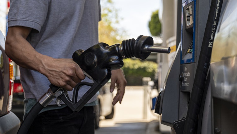 A driver returns a fuel nozzle to a gas pump at a gas station (Photographer: David Paul Morris/Bloomberg via Getty Images)