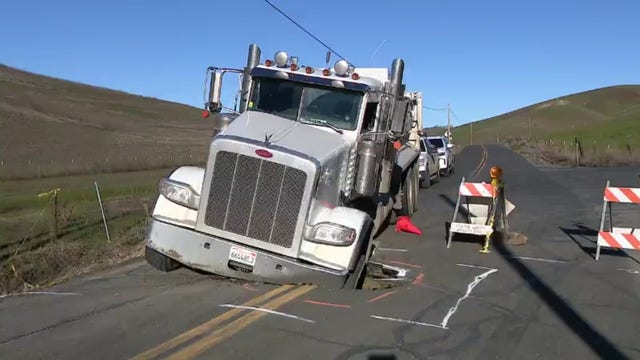 Truck gets stuck in sinkhole after driving onto closed road