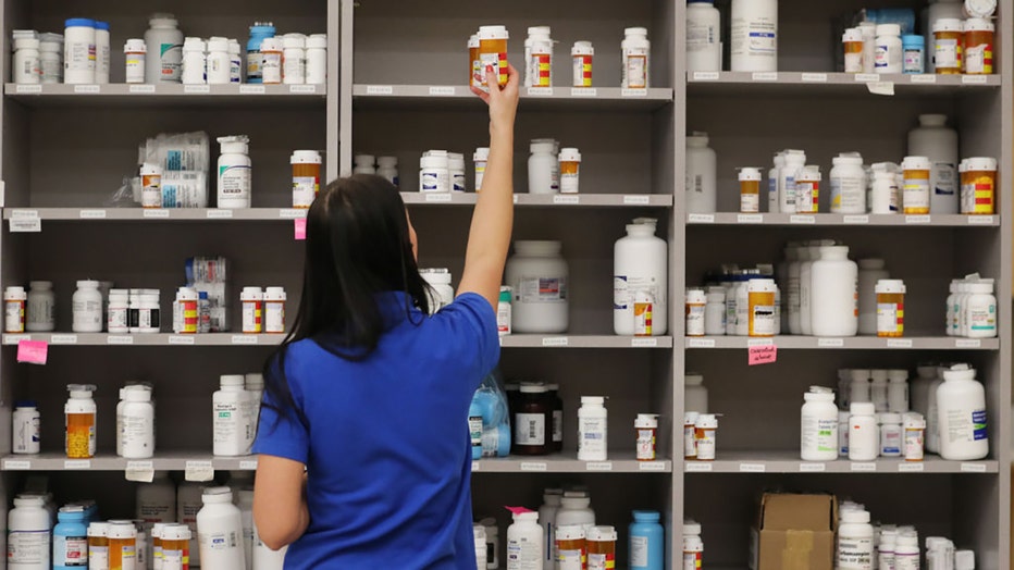 FILE IMAGE - A pharmacy technician grabs a bottle of drugs off a shelve at a pharmacy on Sept. 10, 2018, in Midvale, Utah. (Photo by George Frey/Getty Images)
