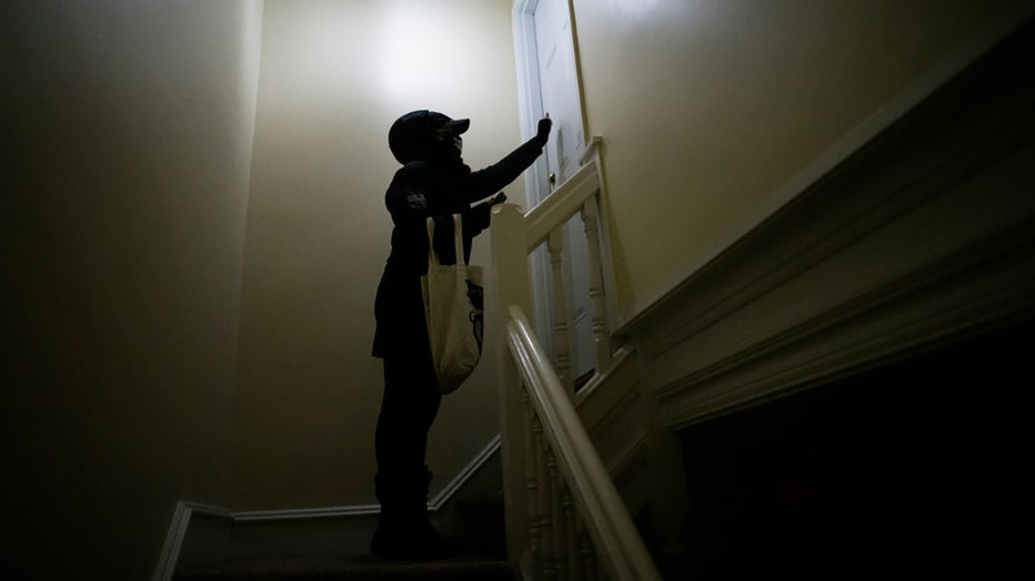 FILE - A person knocks on a door in Landsdowne, Pennsylvania, in a file image dated Nov. 1, 2020. (Photo by Mark Makela/Getty Images)