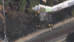 Grass fire burning by train tracks damages home in Fremont