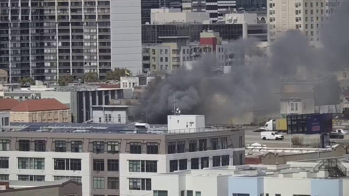 Firefighters douse flames at burning building in Oakland, near Webster and 6th streets