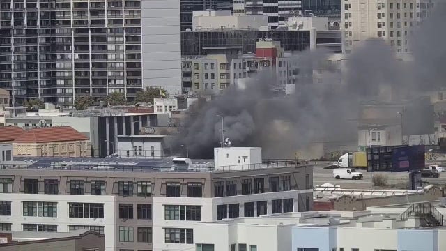 Firefighters douse flames at burning building in Oakland, near Webster and 6th streets