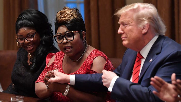 FILE - Then-President Donald Trump reacts as social media personalities Lynnette Hardaway (L) and Rochelle Richardson (2-L), otherwise known as Diamond and Silk, speak during a meeting with African-American leaders in the Cabinet Room of the White House in Washington, DC, on Feb. 27, 2020. (Photo by NICHOLAS KAMM/AFP via Getty Images)