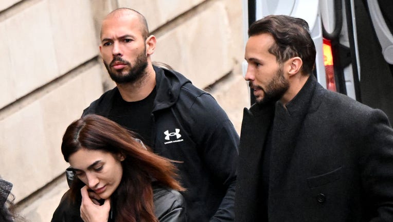 FILE - British-U.S. former professional kickboxer and controversial influencer Andrew Tate (C), and his brother Tristan Tate (R) arrive handcuffed and escorted by police at a courthouse in Bucharest on Jan. 10, 2023, for a court hearing on their appeal against pre-trial detention for alleged human trafficking, rape and forming a criminal group. (Photo by DANIEL MIHAILESCU/AFP via Getty Images)