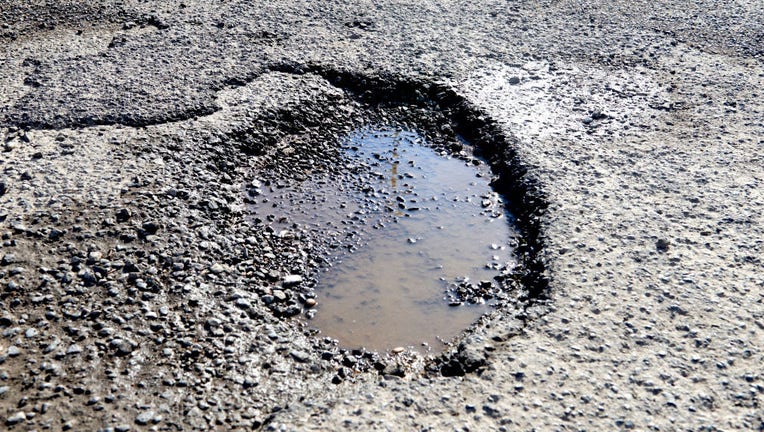 FILE - A pothole filled with water in a road on June 10, 2022 in London, England. (Photo by Peter Dazeley/Getty Images)