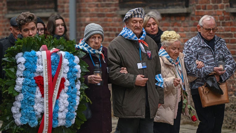Survivors of the Auschwitz concentration camp and families arrive to lay wreaths honoring victims of the Nazi regime by the death wall during the Holocaust Remembrance day at the former Auschwitz I site on Jan. 27, 2023 in Oswiecim, Poland. International Holocaust Remembrance Day, 27 January, is observed on the anniversary of the liberation of Auschwitz-Birkenau, the largest Nazi death camp. (Photo by Omar Marques/Getty Images)