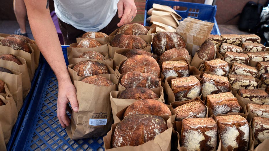 FILE IMAGE - A bakery worker arranges a display of artisan breads at a vegetable market in downtown Denver, Colorado. (Photo by Robert Alexander/Getty Images)