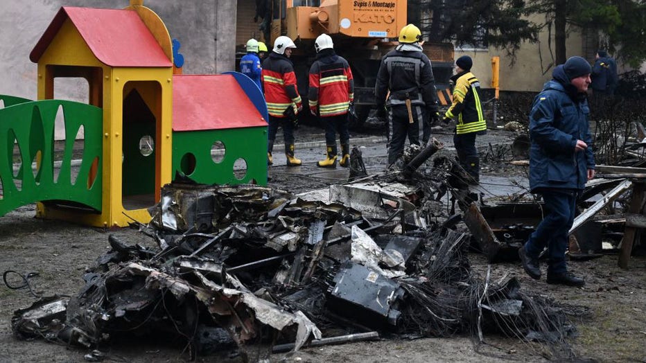 Firefighters work near the site where a helicopter crashed near a kindergarten in Brovary, outside the capital Kyiv, killing several people, including children and the Ukrainian interior minister, on Jan. 18, 2023, amid the Russian invasion of Ukraine. (Photo by SERGEI SUPINSKY/AFP via Getty Images)
