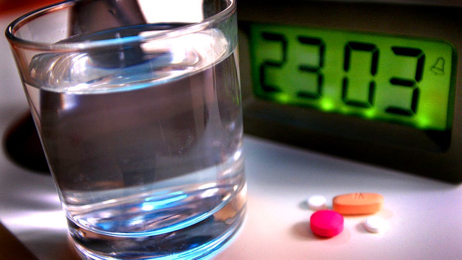 FILE - A night scene with a selection of medication and a glass of water. (Photo by: Newscast/Universal Images Group via Getty Images)