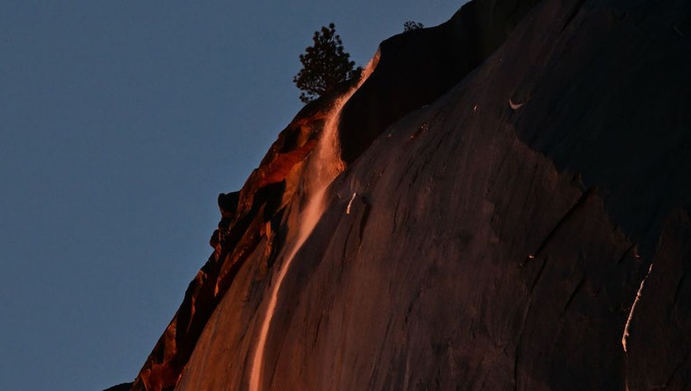 Water flowing off Horsetail Fall glows orange while backlit by the setting sun during the "Firefall" phenomenon in Yosemite National Park, California on Feb. 15, 2023. (Photo by FREDERIC J. BROWN/AFP via Getty Images)
