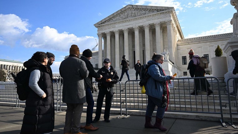 People wait in line outside the US Supreme Court in Washington, DC, on Feb. 21, 2023, to hear oral arguments in two cases that test Section 230, the law that provides tech companies a legal shield over what their users post online. (Photo by JIM WATSON/AFP via Getty Images)