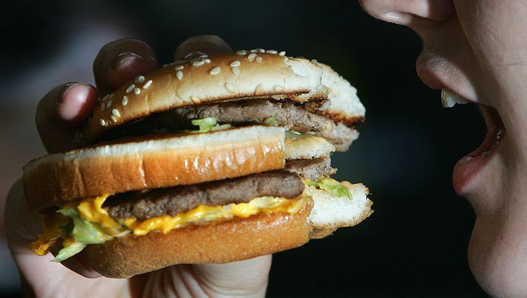 FILE IMAGE - In this photo illustration, a person eats a hamburger on July 12, 2007, in London, England. (Photo illustration by Cate Gillon/Getty Images)