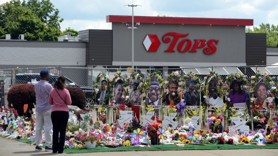 Community members pay respects at a "Memorial Garden" filled with flowers, photos and mementos outside the Tops Friendly Market on Jefferson Avenue on July 14, 2022, in Buffalo, New York. (Photo by John Normile/Getty Images)