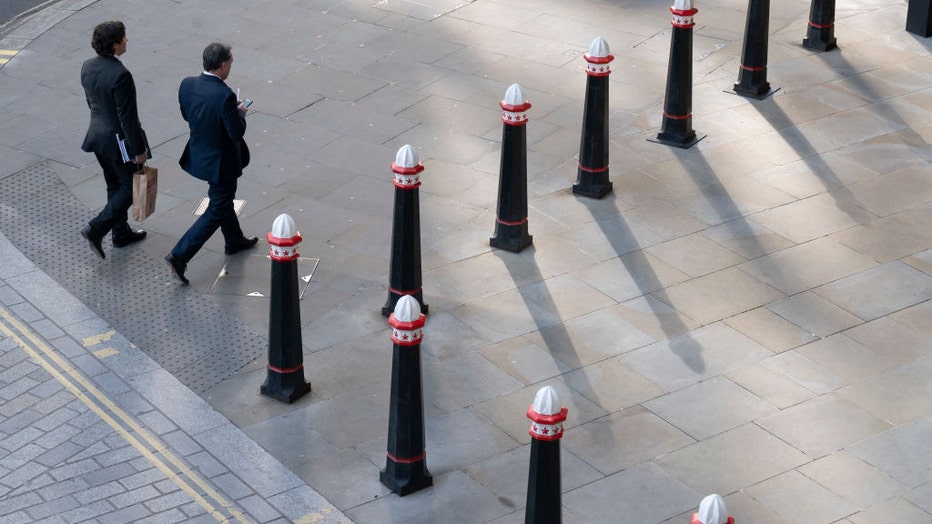 FILE - Two businessmen walk through Corporation of London bollards and into an office property on a street corner on London Wall in the City of London, the capital's financial district, on Feb. 7, 2023, in London, England. (Photo by Richard Baker / In Pictures via Getty Images)