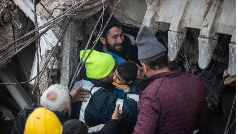 Rescue workers carry Yigit Cakmak, an 8-year-old survivor at the site of a collapsed building 52 hours after the earthquake struck, on Feb. 8, 2023, in Hatay, Turkey. (Photo by Burak Kara/Getty Images)