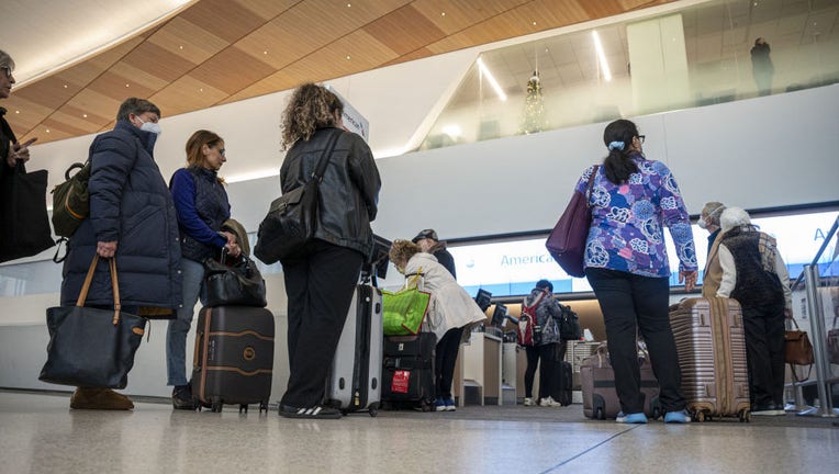 Travelers wait to check-in at the American Airlines counter at San Francisco International Airport (SFO) in San Francisco, California, US, on Dec. 27, 2022. Photographer: David Paul Morris/Bloomberg via Getty Images