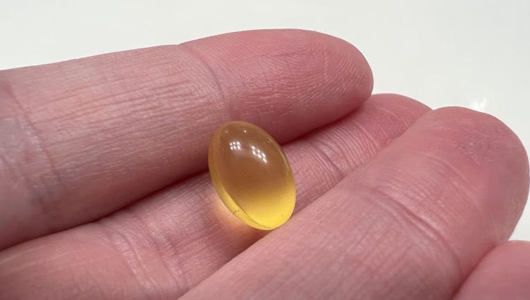 A person's hand holds a small vitamin D supplement in a file image dated Jan. 4, 2022. (Photo by Smith Collection/Gado/Getty Images)