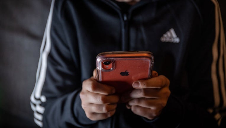 FILE - A 12-year-old boy looks at a smartphone screen on March 16, 2023 in Bath, England. (Photo by Matt Cardy/Getty Images)