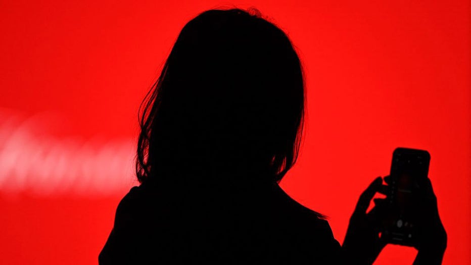 FILE IMAGE - A person holds their smartphone on April 8, 2021. (Photo by GABRIEL BOUYS/AFP via Getty Images)