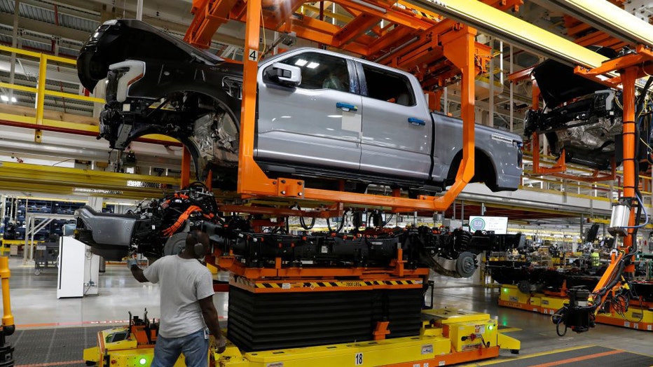 FILE - The truck cab is lowered on the frame of Ford Motor Co. battery powered F-150 Lightning trucks under production at their Rouge Electric Vehicle Center in Dearborn, Michigan on Sept. 20, 2022. (Photo by JEFF KOWALSKY/AFP via Getty Images)
